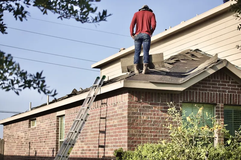 Professional roofer working on a residential roof in Remus